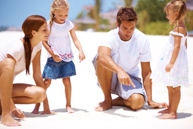 Family Time Together-Parents Playing With Kids At The Beach In The Sun