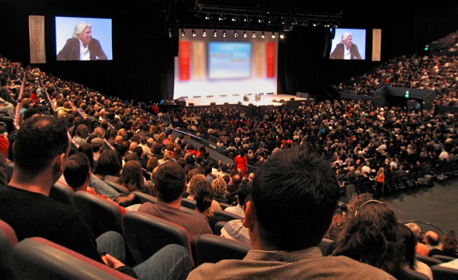 Richard Branson Speaking From Stage In Conference